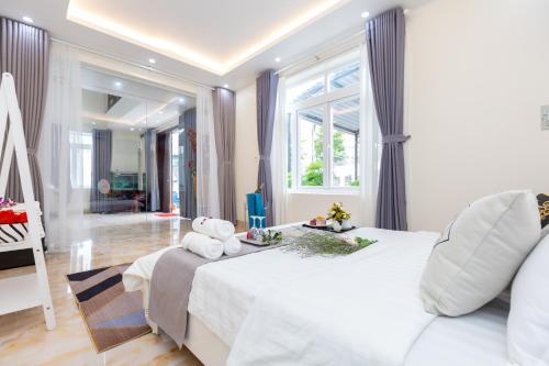 sypialnia z białym łóżkiem z pluszowym misiem w obiekcie Palm Villa 7 w mieście Vung Tau
