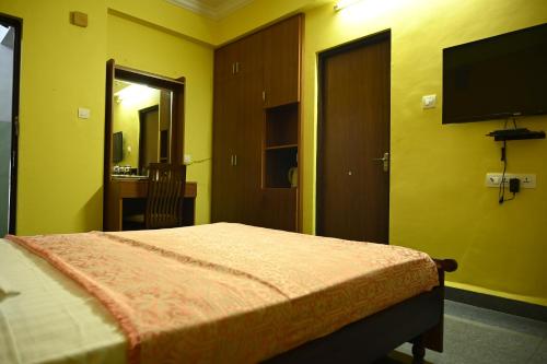 a bedroom with a bed and a flat screen tv at Hotel Siesta De Goa in Varca