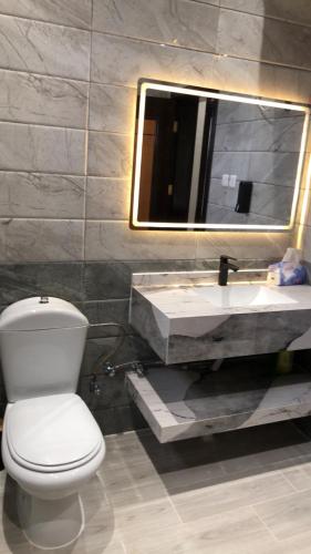 a bathroom with a white toilet and a sink at شقة خاصه مطله على الجبل in Al Baha