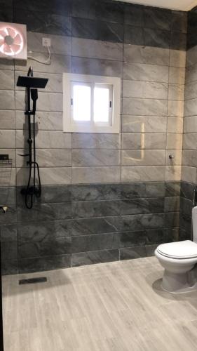 a bathroom with a toilet and a window at شقة خاصه مطله على الجبل in Al Baha