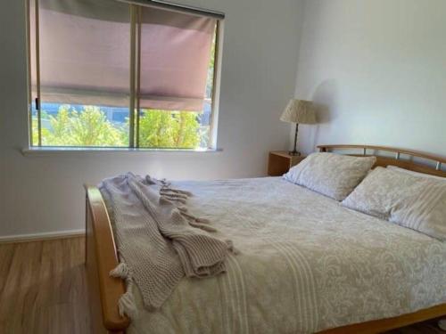 a bedroom with a large bed with a window at Eos 2 in Esperance