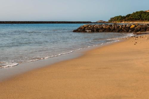a sandy beach with rocks in the water at Ananthaya Beach in Tangalle