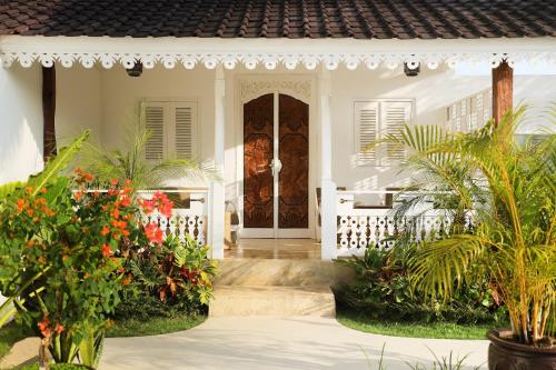 a front door of a white house with plants at Puri Tempo Doeloe Boutique Hotel in Sanur