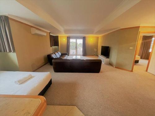 a large living room with a couch and a bed at Emily St Escape in Esperance