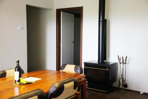 a dining room with a wooden table and a wood stove at Bella Vista Bellingen in Bellingen