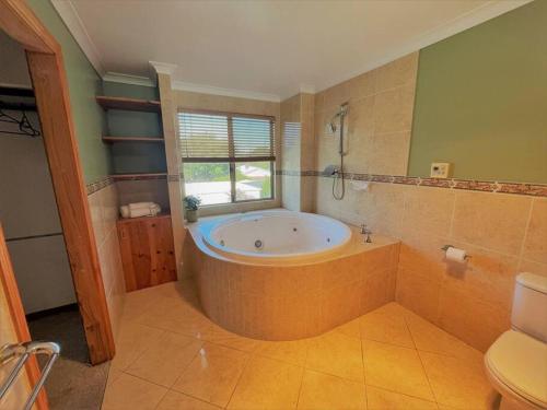 a large bathroom with a tub and a window at Emily St Escape in Esperance