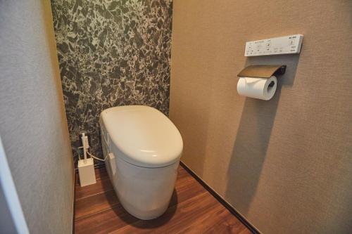 a bathroom with a toilet and a roll of toilet paper at ルクス箱根湯本 LUX HAKONE YUMOTO in Hakone