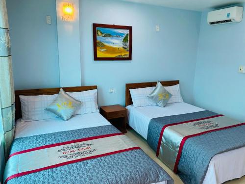 duas camas sentadas uma ao lado da outra num quarto em Nhà nghỉ Hưng Thơm em Ilha de Cát Bà
