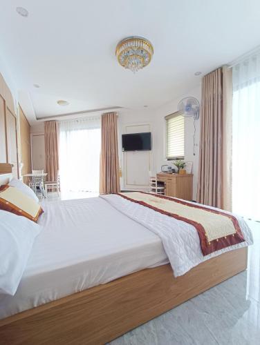 a large bedroom with a large white bed and a tv at Kami Hotel in Kinh Dinh