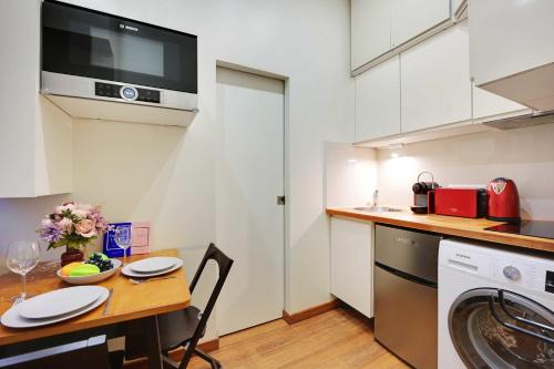 une petite cuisine avec une table et un micro-ondes dans l'établissement Cosy apartment - 1BR-3P - Arc de Triomphe, à Paris