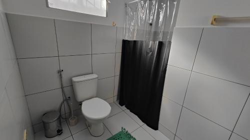 a bathroom with a toilet and a black shower curtain at Linda casa no Alvorada II in Parnaíba