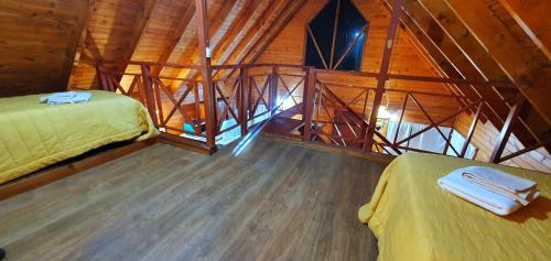 a room with two beds in a wooden cabin at Entre montañas in San Carlos de Bariloche