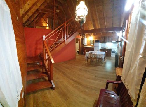 a room with a staircase and a dining room and kitchen at Entre montañas in San Carlos de Bariloche