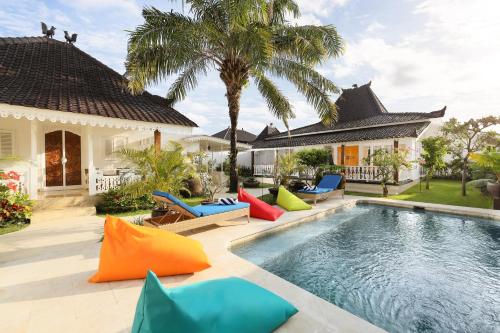a swimming pool with colorful chairs and a house at Puri Tempo Doeloe Boutique Hotel in Sanur