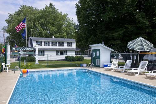 - une piscine avec des chaises et une maison dans l'établissement Mount Coolidge Motel, à Lincoln