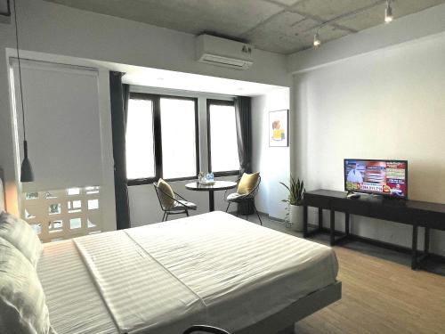 - une chambre avec un lit et une table avec des chaises dans l'établissement Kem Apart 01, à Hanoï