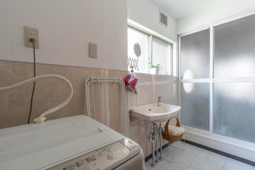 a small bathroom with a sink and a washing machine at My Retreat Osaka in Osaka