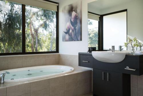 a bathroom with a tub and a sink at Lake Daylesford Lodge 6 in Daylesford