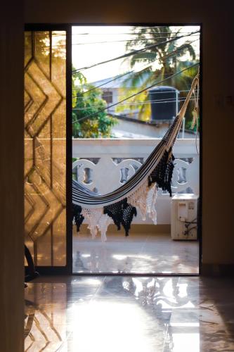 een hangmat hangt in een kamer met een raam bij Casa a una cuadra del mar in Tolú