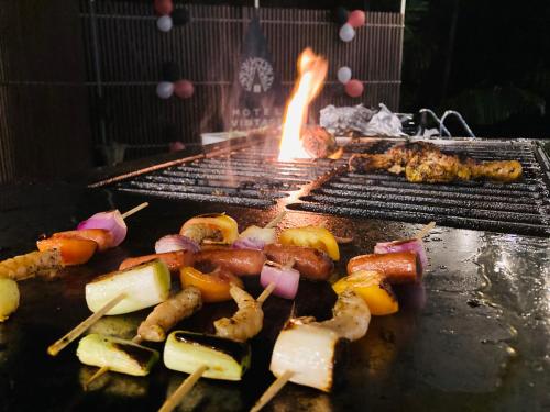 a bunch of food on a grill with fire at Motel Vintage Beliatta in Beliatta