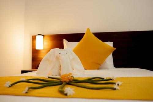 a hotel room with a bed with towels and flowers on it at Iora Resort Habarana in Habarana