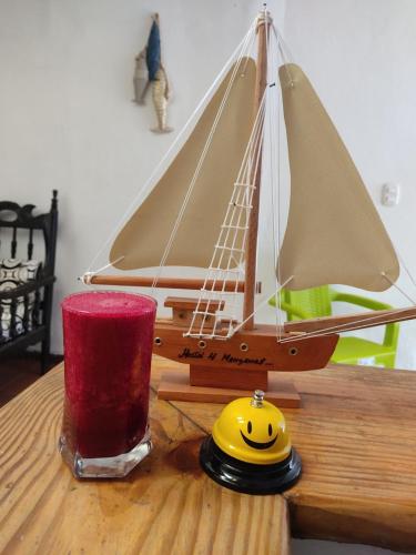 a toy boat on a wooden table with a candle at Hostal 4 Manzanas in Santa Marta