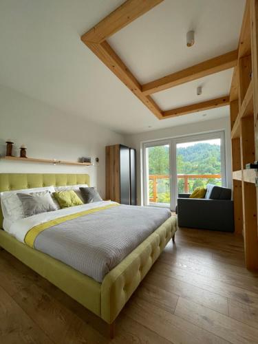 een slaapkamer met een groot bed en een groot raam bij HARLEY FAMILY APARTAMENT in Muszyna