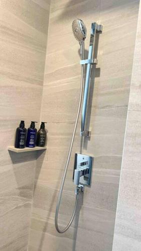 a shower with a shower head in a bathroom at BJ Edge Central Pattaya in Pattaya
