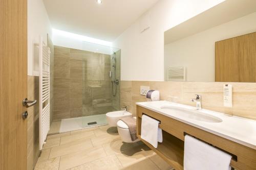 a bathroom with a sink and a toilet at Hotel CampingPark Steiner in Laives