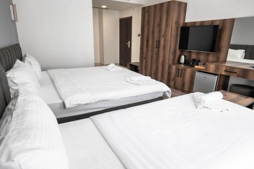 Habitación de hotel con 2 camas y TV de pantalla plana. en Hotel Diamond en Skopje