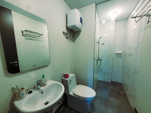 a bathroom with a toilet and a sink and a shower at Palam Mansion at Apartment One Residence in Batam Center