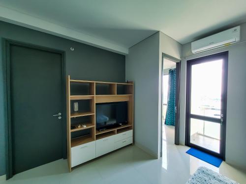 a living room with a tv and a window at Palam Mansion at Apartment One Residence in Batam Center