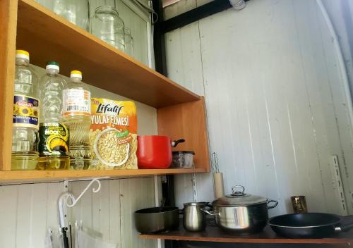 a shelf with bottles of alcohol and pots and pans at Green Palma in Kutaisi