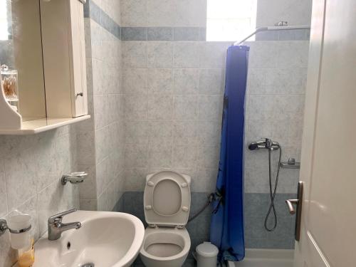 a bathroom with a toilet and a sink and a shower at enJoy in Tripoli