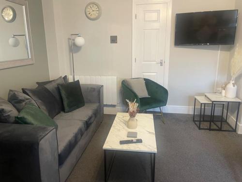a living room with a couch and a table at Fern House by Shortstays4u A Beautiful 2bedroom Townhouse with free parking in the town! in King's Lynn