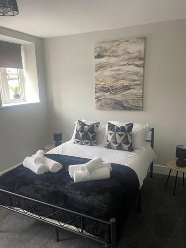a bedroom with a bed with two towels on it at Fern House by Shortstays4u A Beautiful 2bedroom Townhouse with free parking in the town! in King's Lynn