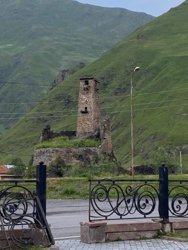 an old stone tower sitting on top of a hill at Under the forest in Kazbegi