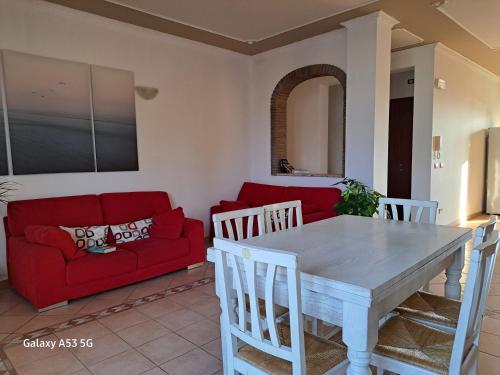 聖多納托的住宿－La casa di là.，客厅配有红色的沙发和桌子