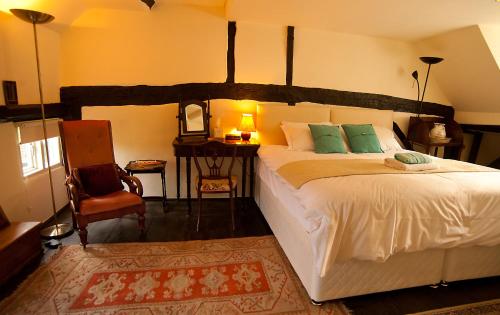 a bedroom with a large bed and a chair at The Old Stables B&B in Winslow