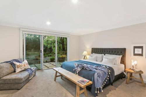 a bedroom with a bed and a couch at Lakes Edge in Daylesford