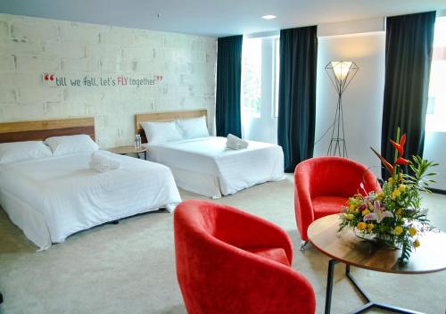 a hotel room with two beds and a table and chairs at Hotel Regal Vista in Ipoh