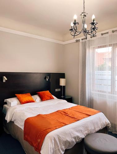 a bedroom with a large bed with orange pillows at Excelsior INN in Turda