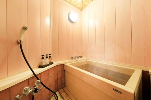 a bath tub in a bathroom with a shower at 日長庵 桂月 in Hirugami