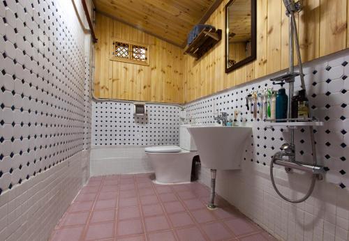 a bathroom with a white toilet and a sink at Dongmyo Hanok Sihwadang - Private Korean Style House in the City Center with a Beautiful Garden in Seoul