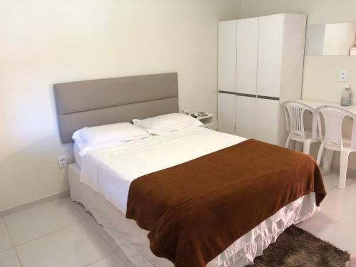 Un dormitorio con una cama y una mesa y sillas. en Apartamento Villa do Porto, a 300 metros do Beach Park, en Aquiraz