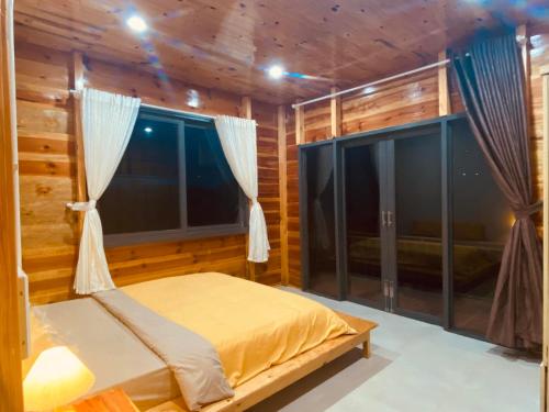 a bedroom with a bed and a window at Lam Nguyên Farm Stay in Bao Loc