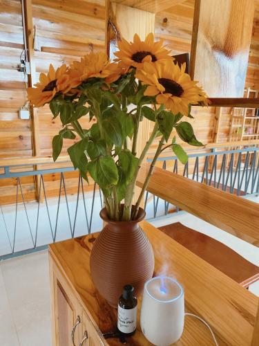 a vase filled with yellow flowers sitting on a table at Lam Nguyên Charming House in Bao Loc