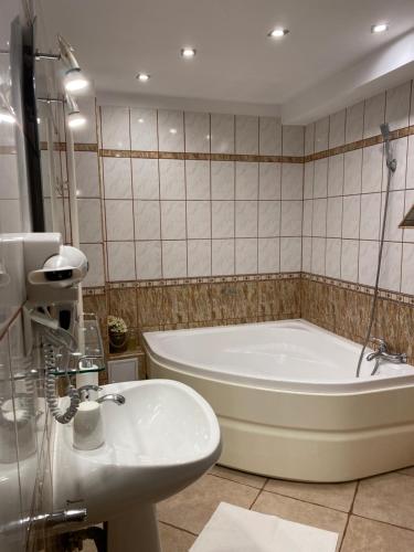 a bathroom with a bath tub and a sink at Vila Dani in Sinaia