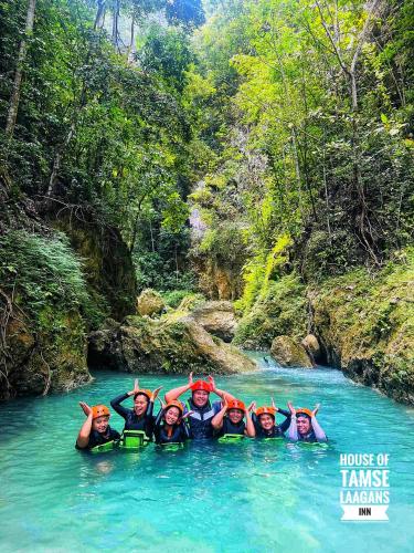 a group of people in the water in a river at House of TamSe Laagans ' Inn in Badian