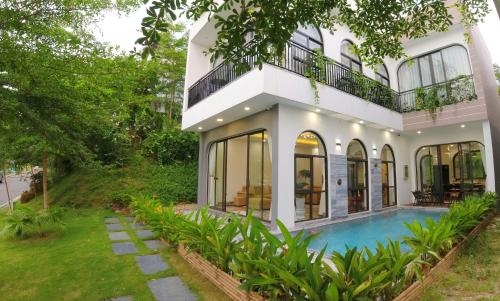 een huis met een zwembad ervoor bij The Oxford Villa at Venus by Flamingo Dai Lai Resort in Phúc Yên
